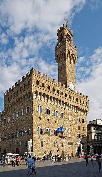 Palazzo Vecchio from Piazza della Signoria, with the bell tower and clock. in front of it, left to right, the Neptune fountain, the David by Michelangelo, and Heracles.